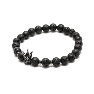 Close-up of black lava rock beads and silver crown charm with micro-pave stones