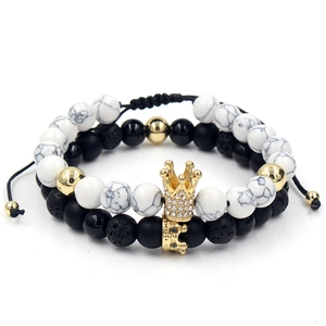 Dettaglio di bracciali con perline, corona dorata, pietre di marmo bianco e pietra lavica