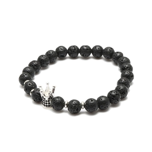 Detail of black lava stone beaded bracelet with silver crown charm and micro-inlay