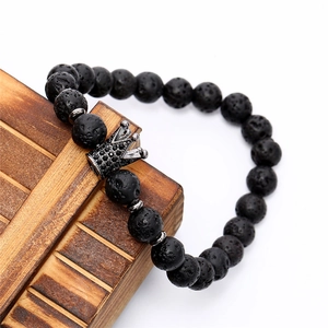 Macro view of black lava stone beads and a crown charm with black micro-inlaid zircons
