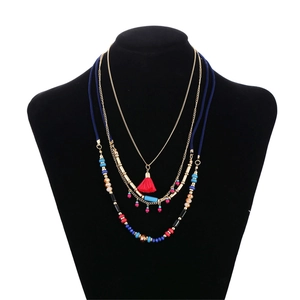 Bohemian multilayer beaded necklace with golden chains and vibrant red tassel pendant