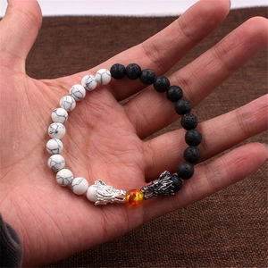 Dettaglio del bracciale testa di drago con turchese bianco, pietra lavica e perla arancio