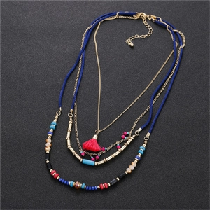 Bohemian multi-layer seed bead necklace with vibrant red tassel and golden chains