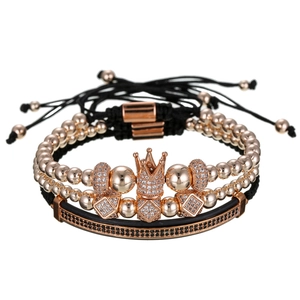 Close-up van driedelige sieradenset met roségouden kroonarmband en zwarte accenten