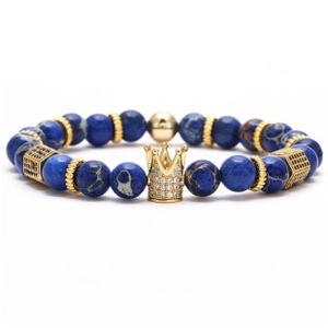 Macro detail of Bohemian beaded bracelet with gold crown charm and blue gemstone beads