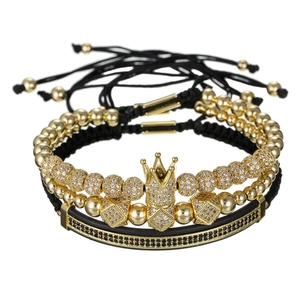 Detalle de primer plano de un conjunto de tres pulseras con corona y bolas de pavé