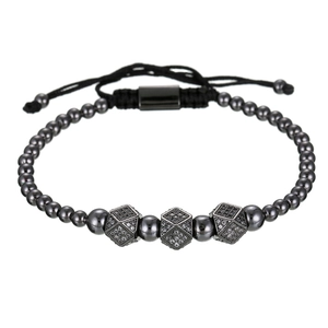 Detail van verstelbare kralenarmband met drie met zirkonia bezette kubussen