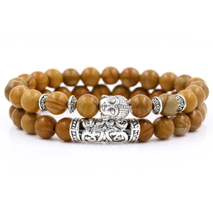 Detail of stone bead bracelet set with silver Buddha head and textured metal tubes