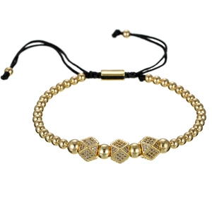 Macro detail van de gouden kralenarmband met zirkonia bedeltjes en zwart koord
