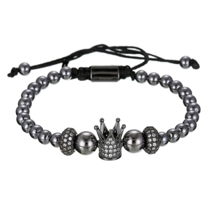 Macrodetail van herenarmband met kralen, ingelegde zirkoon kroon en gevlochten koordsluiting