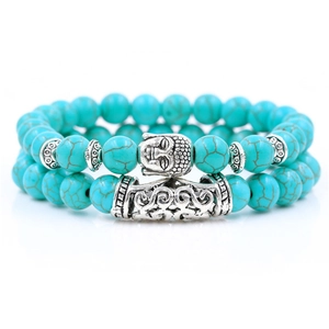 Detail of beaded bracelet set with turquoise stones, buddha head, and hollow metal tube