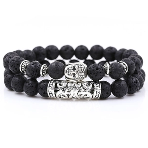 Detailed macro of black lava rock beads and silver Buddha charm on a two-piece bracelet set