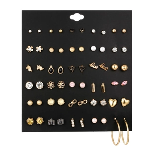 Close-up of 30 pairs earring set with heart, floral, and pearl designs on black display card