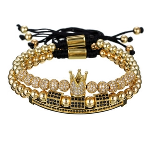 Detail of beaded men's bracelets with gold crown charm and black zircon accents