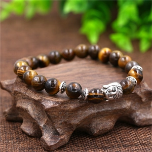 Macro shot of tiger eye beaded bracelet with silver Buddha head and ethnic style spacers