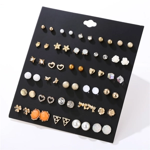Dettaglio di un set da 30 paia di orecchini alla moda con perle, stelle e cuori vari