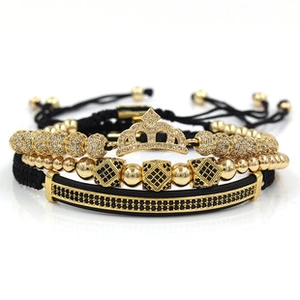 Detailed shot of three-piece men's bracelet set with golden crown and black zircon beads