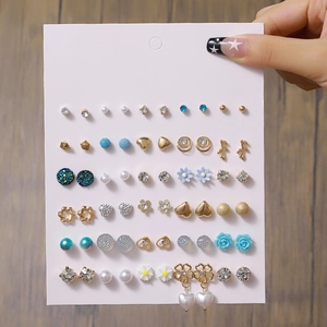 Dettaglio di un set da 30 paia di orecchini con perle e perni di cristallo colorati