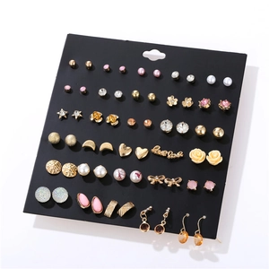 Flat lay of 30 pairs assorted gold earrings set including pearls and rhinestones