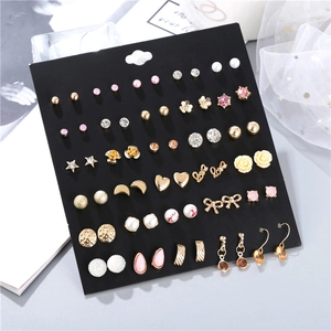 Detailed set of thirty assorted metal and pearl earrings displayed on a black card