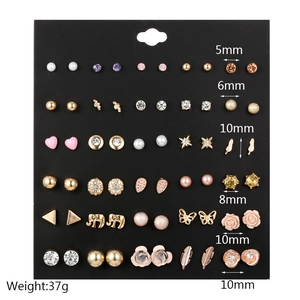 Detailed view of 30 pairs of gold and silver stud earrings with pearls and rhinestones