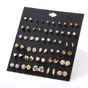Detailed close-up of 30 pairs earring set featuring pearls and rhinestones on black card