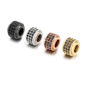 Vue macro de quatre breloques cylindriques avec pierres noires pour bijoux DIY