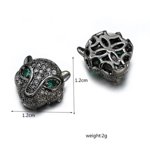 Macro detail of leopard head beads with white pavé crystals and green emerald-like eyes