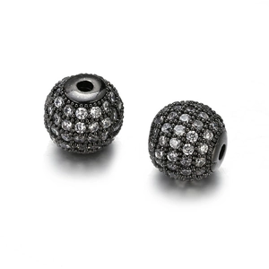 Detalle macro de cuentas de cobre chapadas en negro de 10mm con circonitas brillantes