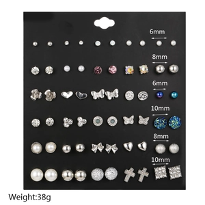 Close-up of a 30-pair stud earring set featuring pearls and rhinestones on black board