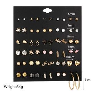 Detailed set of 30 pairs golden geometric earrings with pearls and crystals on display card