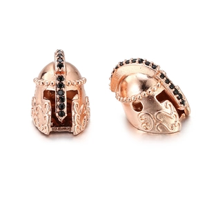 Macro shot of rose gold knight helmet charm with black zircon stones and scroll patterns