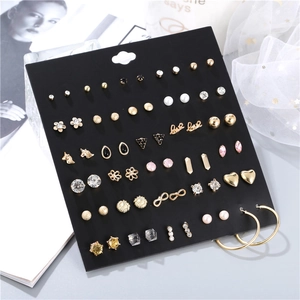 Detailed set of 30 pairs assorted stud earrings with pearls and crystals on display
