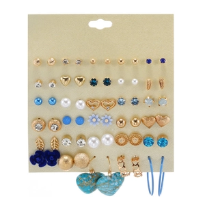 Close-up of assorted gold-tone earrings with pearls, crystals, and geometric designs