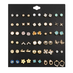 Set di 30 paia di orecchini dorati misti con stelle, perle e cristalli su cartoncino nero