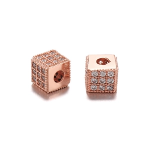 Macro-opname van roségouden kubuskralen met micro-pave zirkonia en zijdelingse gaten