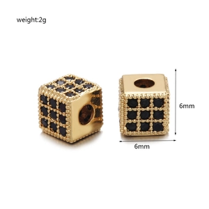 Detailopname van een 6mm gouden kubusvormige kraal met zwart zirkonia micropavé