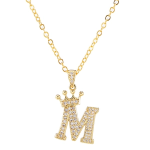 Macro-opname van gouden letter M-hanger met zirkonia kroon en details van de kruisketting