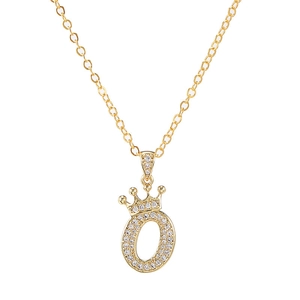 Detail van gouden kroonletter O hanger met schitterende zirkonia aan een schakelketting