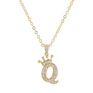 Detail van gouden ketting met zirkoon kroon en letter Q hanger aan een subtiele schakelketting
