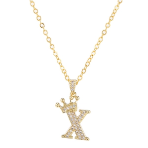 Detail van gouden letter K ketting met zirkoon kroon hanger aan een fijne schakel