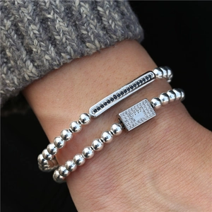 Men's punk beaded bracelet set with crown zircon charms worn on grey knit sweater sleeve