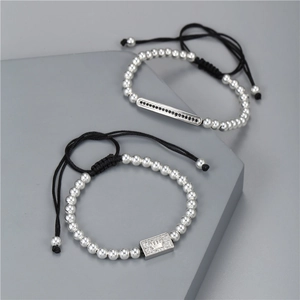 Close-up of woven adjustable bracelet set with rectangular crown pendant and zircons