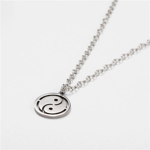 Macro detail of silver stainless steel Tai Chi Yin Yang pendant with polished finish