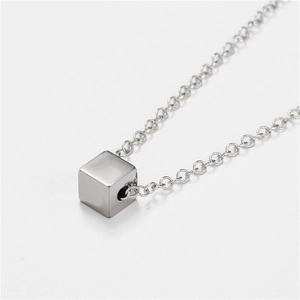 Macro view of a minimalist silver cube pendant on a durable stainless steel O-chain