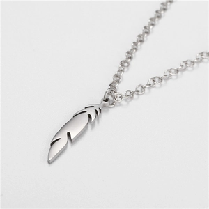 Detail of silver feather pendant necklace featuring intricate textures on stainless steel