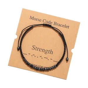Detail of Morse code braided bracelet with Strength card and hematite stone beads