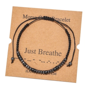 Detail of Morse code bracelet with black beads and 'Just Breathe' handmade display card