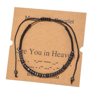 Detail of handmade Morse code bracelet with black beads on craft card featuring quote text