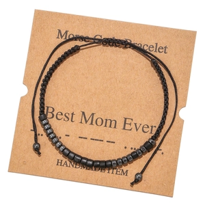 Detail of Morse Code handmade woven bracelet with black beads on a Kraft card